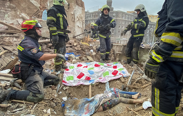 Rescuers release the body of 10-year-old boy Tymofii from debris at a site of a residential building damaged by a Russian missile strike, amid Russia's attack on Ukraine, in Kharkiv, Ukraine on October 6, 2023. (Photo by Vitalii Hnidyi/Reuters)