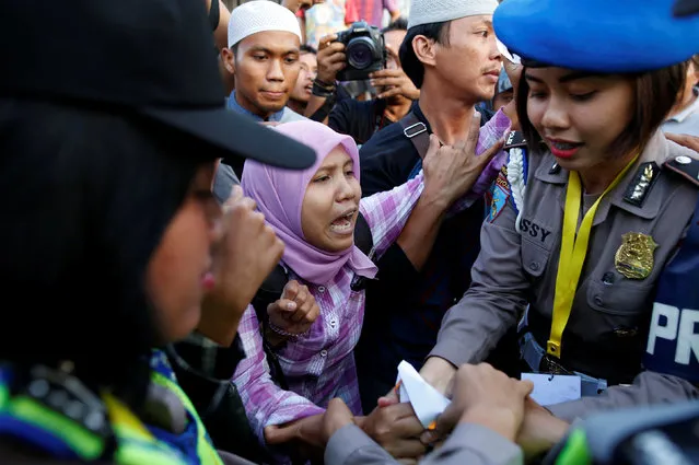 Police remove a protester who was part of a small group rallying in support of a female death-row prisoner near the gate to the ferry port for the prison island of Nusa Kambangan island, ahead of the expected execution of 14 drug convicts including at least four foreigners in Cilacap, Central Java, Indonesia July 28, 2016. (Photo by Darren Whiteside/Reuters)