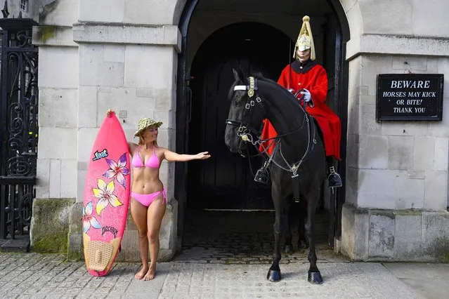 Hawaiian “protest surfer” Alison Teal stands with her surfboard by a Horse Guard during a visit to London on March 6, 2020, to raise awareness on the need to combat climate change. Alison Teal, after tackling wastewater in Mexico, paddling the River Seine in Paris and a garbage island in the Maldives, travels the world with her pink “eco-friendly” surfboard to raise awareness about the environment. (Photo by Olivier Morin/AFP Photo)