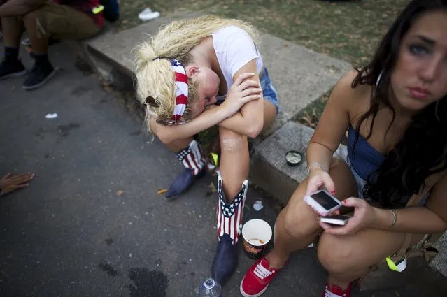 A woman wearing an outfit with the U.S. flag design sleeps on a curb at the Made in America festival in Philadelphia August 30, 2014. The two day music festival is organized by Jay-Z and will have a twin concert in Los Angeles. (Photo by Mark Makela/Reuters)