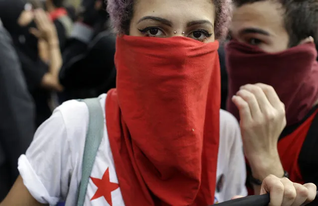 A demonstrator with her face covered marches during a protest on the route of the Olympic torch against the money spent on the Rio's 2016 Summer Olympics, in Niteroi, Brazil, Tuesday, August 2, 2016. The three-month torch relay across Brazil will end at the opening ceremony on Aug. 5, in Rio de Janeiro's Maracana stadium. (Photo by Leo Correa/AP Photo)