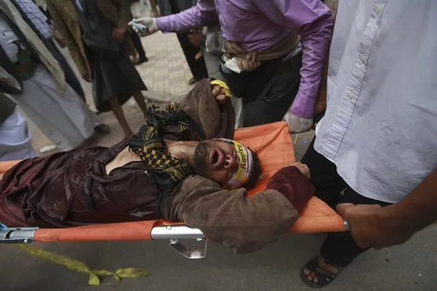 Shi'ite Houthis help a fellow protester suffering from tear gas inhalation during clashes with riot police near the cabinet building in Sanaa September 9, 2014. Yemeni troops and Shi'ite Muslim rebels shot at each other at the Western entrance to the capital Sanaa, residents and security sources said, hours after soldiers killed at least four protesters outside the cabinet building. (Photo by Mohamed al-Sayaghi/Reuters)