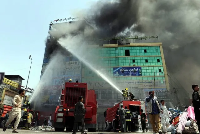 Fire fighters extinguish fire at a shopping mall, in Kabul, Afghanistan, 04 August 2016. Hundreds of shops were gutted, inflicting loses amounting to hundreds of thousands of US dollars, one man was killed in this incident. (Photo by Hedayatullah Amid/EPA)