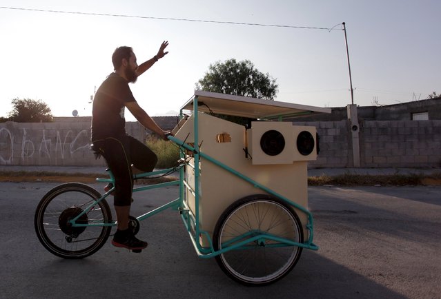 Reginaldo Chapa pedals his Cinecleta, Moviebike, through the streets of Saltillo, Mexico, September 6, 2015. Chapa modified a cargo bike to create the Cinecleta, a pedal-driven vehicle that carries a solar powered battery, a projector and sound equipment which it's aimed to promote clean energy and to take films and music to rough neighbourhoods in this industrial city, local media reported. (Photo by Daniel Becerril/Reuters)