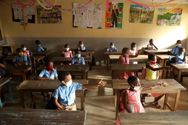 Pupils, wearing protective masks, attend courses in at the Merlan school of Paillet during the reopening of schools, as the lockdown due to coronavirus disease (COVID-19) is eased, in Abidjan, Ivory Coast on May 25, 2020. (Photo by Luc Gnago/Reuters)