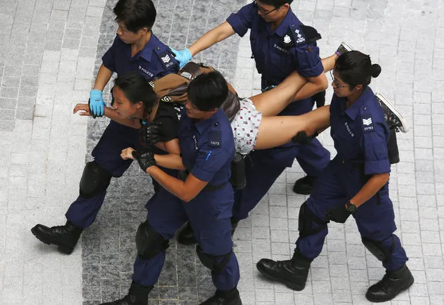 A protester is taken away by policewomen after storming into the government headquarters in Hong Kong September 27, 2014. (Photo by Bobby Yip/Reuters)