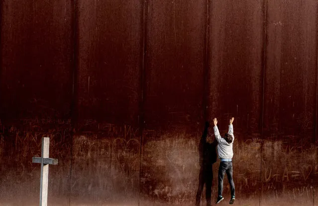 A man jumps in front of a metal wall, part of the Berlin Wall memorial site in Berlin, Germany, 08 November 2017. November 09th marks a significant date in German history when both the Fall of the Berlin Wall as well as the “Kristallnacht” or “Reichskristallnacht” (lit.: Crystal Night, or Night of Broken Glass) are commemorated. (Photo by Filip Singer/EPA/EFE)