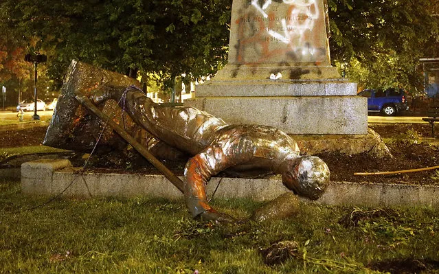 A statue from the Richmond Howitzers Monument in Richmond, Va., lies after being toppled Tuesday night, June 16, 2020, in Richmond, Va. The monument was erected in 1892 to commemorate a Richmond Civil War artillery unit. (Photo by Alexa Welch Edlund/Richmond Times-Dispatch via AP Photo)