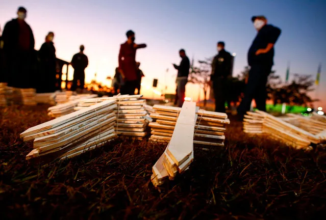 Demonstrators take part in a protest against Brazilian President Jair Bolsonaro and in honour of the people who died of COVID-19 in which 1000 crosses were placed in front of the National Congress in Brasilia, on June 28, 2020, amid the novel coronavirus pandemic. The pandemic has killed at least 495,288 people worldwide, including more than 55,000 in Brazil, since it surfaced in China late last year, according to an AFP tally at 1900 GMT on Saturday, based on official sources. (Photo by Sergio Lima/AFP Photo)