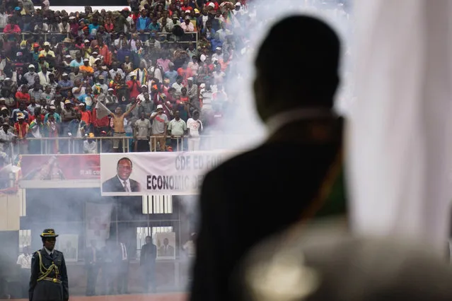 Smoke rises from cannon as the military regiment makes a 21-gun salute during the inauguration of  Zimbabwes new President Emmerson Mnangagwa (R) on November 24, 2017. Emmerson Mnangagwa was sworn in as Zimbabwe's President on November 24, marking the final chapter of a political drama that toppled his predecessor Robert Mugabe after a military takeover. Mnangagwa, until recently one of Mugabe's closest allies, took the oath of office at the national sports stadium on the outskirts of Harare to an explosion of cheering from the full-to-capacity crowd. (Photo by Zinyange Auntony/AFP Photo)