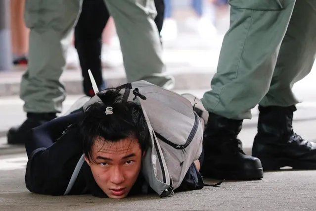 A man lies on the ground as he is detained by riot police during a march against the national security law at the anniversary of Hong Kong's handover to China from Britain in Hong Kong, China on July 1, 2020. (Photo by Tyrone Siu/Reuters)