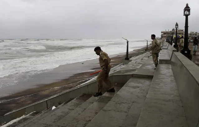 Policemen patrol as they evacuate a beach on the Bay of Bengal coast at Gopalpur, Orissa, about 285 kilometers (178 miles) north east of Visakhapatnam, India, Sunday, October 12, 2014. A powerful cyclone was pounding a large swath of India's eastern seaboard with heavy rain and strong winds on Sunday, killing at least two people and causing major damage to buildings and crops, in one of two storms lashing Asia. (Photo by Biswaranjan Rout/AP Photo)