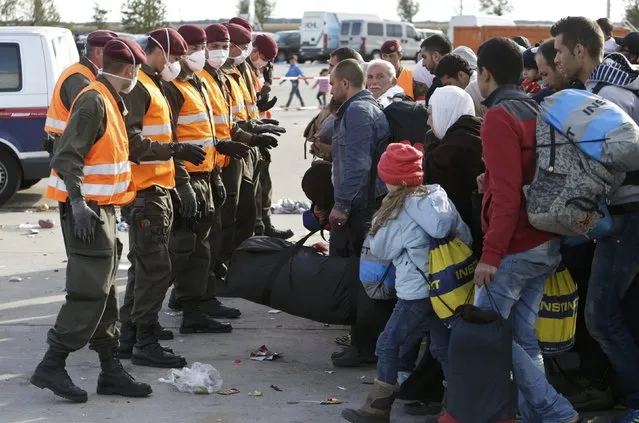 Austrian soldiers line up in front of migrants the Austria-Hungaria border in Nickelsdorf, Austria, September 20, 2015. (Photo by David W. Cerny/Reuters)