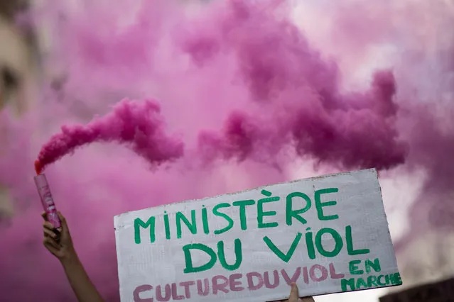 A protester holds a sign reading “Ministry of rape” as another lights a pink flare during a demonstration called by feminist movements in Nantes, western France, on July 10, 2020, to denounce the nomination of French Interior Minister, facing rape accusations and French Justice Minister who criticised the #MeToo movement against sexual harassment. (Photo by Loic Venance/AFP Photo)