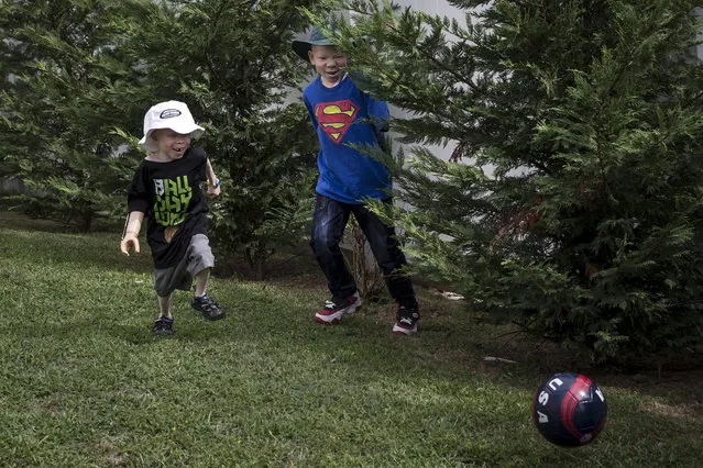 5-year old Baraka Cosmas (L) and 12-year-old Mwigulu Matonage from Tanzania play soccer in the backyard. (Photo by Carlo Allegri/Reuters)