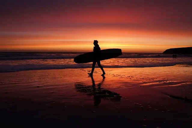 A surfer enters the water at Tynemouth Longsands beach before sunrise on Friday, September 30, 2022. (Photo by Owen Humphreys/PA Images via Getty Images)