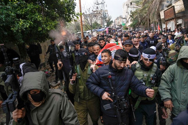 Palestinian gunmen fire into the air as they march with the body of Nabil Amer, 19, killed in an Israeli military raid in the West Bank refugee camp of Tulkarem, West Bank on February 21, 2024. (Photo by Majdi Mohammed/AP Photo)