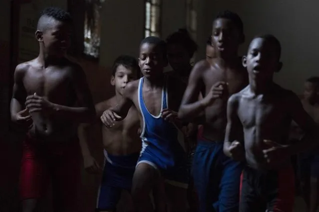 Children exercise during a wrestling lesson at an old Basque ball gymnasium in downtown Havana, October 23, 2014. (Photo by Alexandre Meneghini/Reuters)