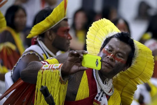 An indigenous man from the Kayapo tribe takes a picture as he arrives to participate in the I World Games for Indigenous People in Palmas, Brazil, October 20, 2015. (Photo by Ueslei Marcelino/Reuters)