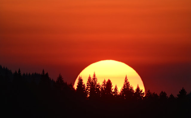 Bands of wildfire smoke from a nearby fire color the sky and setting sun orange as seen from near Elkton in southwestern Oregon on August 12, 2025. The National Weather Service has issued a Heat Advisory for the area with temperatures reaching around 100 degrees on Tuesday. (Photo by Robin Loznak/ZUMA Press Wire/Rex Features/Shutterstock)