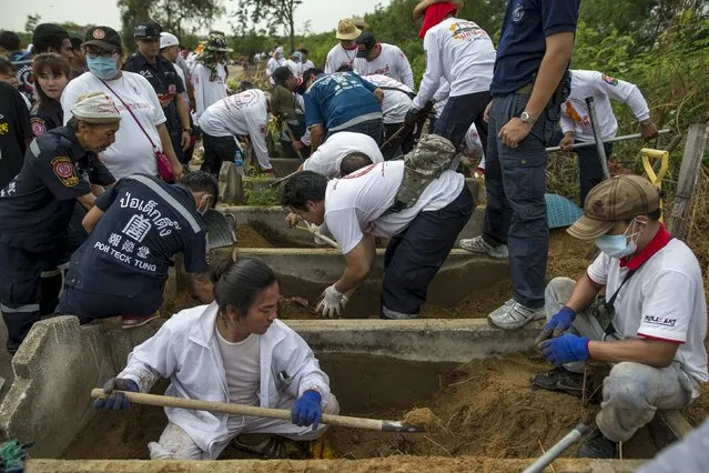 Volunteers dig out the remains of unclaimed bodies from a graveyard during a mass exhumation at Poh Teck Tung Foundation Cemetery in Samut Sakhon province, Thailand November 3, 2015. (Photo by Athit Perawongmetha/Reuters)
