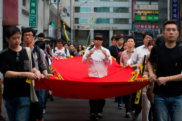 Activists march during the Commemorating Lee Ming- Che’s One Year Of Imprisonment Protest in Taipei on March 19, 2018. Taiwanese human rights activist Lee Ming- cheh has been detained after traveling to China via Macau on March 19, 2017, as China claimed they are investigating him on suspicion of “pursuing activities harmful to national security”. (Photo by  Ashley Pon/AFP Photo)