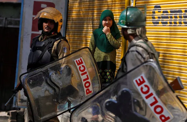 Indian policemen stand guard as a girl watches an anti-India protest in Srinagar, October 7, 2016. (Photo by Danish Ismail/Reuters)