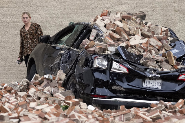 A woman looks at the damage caused by fallen bricks from a building wall in the aftermath of a severe thunderstorm Friday, May 17, 2024, in Houston. Thunderstorms pummeled southeastern Texas on Thursday, killing at least four people, blowing out windows in high-rise buildings and knocking out power to more than 900,000 homes and businesses in the Houston area. (Photo by David J. Phillip/AP Photo)