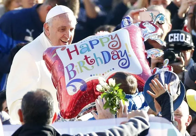 A faithful holds a balloon as Pope Francis, who's 78th birthday is today, arrives to lead his general audience at the Vatican, December 17, 2014. (Photo by Tony Gentile/Reuters)