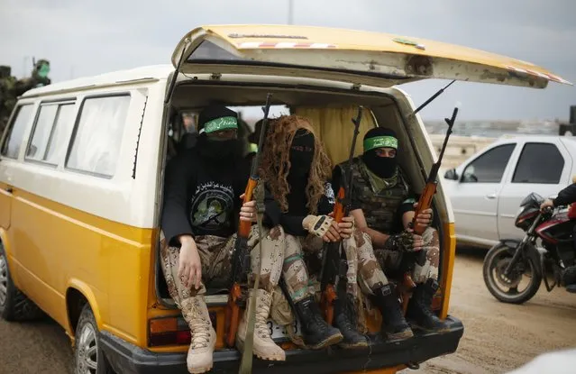 Palestinian members of al-Qassam Brigades, the armed wing of the Hamas movement, sit in a vehicle as they take part in a military parade marking the 27th anniversary of Hamas' founding, in Gaza City December 14, 2014. (Photo by Suhaib Salem/Reuters)