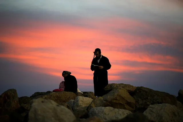 An Ultra-Orthodox Jewish man prays after sunset, along the shore of the Mediterranean Sea in Ashkelon, Israel April 2, 2018. (Photo by Amir Cohen/Reuters)