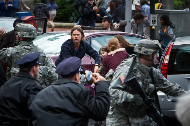 June 21: “World War Z”. Brad Pitt battles zombie apocalypse in $170 million film by “Quantum of Solace” director Marc Forster. This publicity photo released by Paramount Pictures shows, center, Brad Pitt as Gerald Lane in a scene from the film, “World War Z”, from Paramount Pictures and Skydance Productions in association with Hemisphere Media Capital and GK Films. (Photo by Jaap Buitendijk/AP Photo/Paramount Pictures)