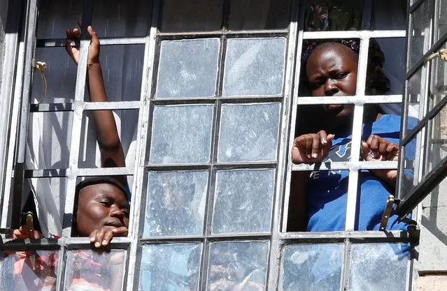 Residents watch from their window as Kenya's opposition leader Raila Odinga of the Azimio la Umoja (Declaration of Unity) One Kenya Alliance, and his supporters participate in a nationwide protest over cost of living and President William Ruto's government in Kawangware neighbourhood of Nairobi, Kenya on March 27, 2023. (Photo by Monicah Mwangi/Reuters)