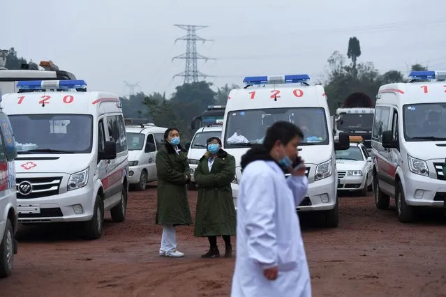 Rescue personnel wait beside parked ambulances outside the Diaoshuidong coal mine in southwestern China's Chongqing on December 5, 2020, after a carbon monoxide leak at the facility left 18 dead, with rescue efforts under way to reach five others still trapped underground. (Photo by AFP Photo/China Stringer Network)