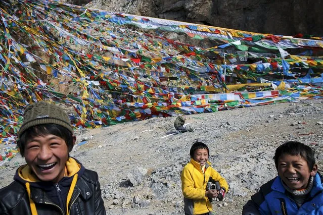 Tibetan boys smile in front of prayer flags place on a rock over Namtso lake in the Tibet Autonomous Region, China November 18, 2015. (Photo by Damir Sagolj/Reuters)