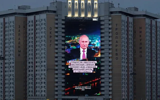 An electronic screen, installed on the facade of a hotel, shows an image of Russian President Vladimir Putin and a quote from his annual address to the Federal Assembly in Moscow, Russia on January 15, 2020. The quote reads: “I propose to provide free hot meals to all elementary school students from grades 1 to 4”. (Photo by Evgenia Novozhenina/Reuters)