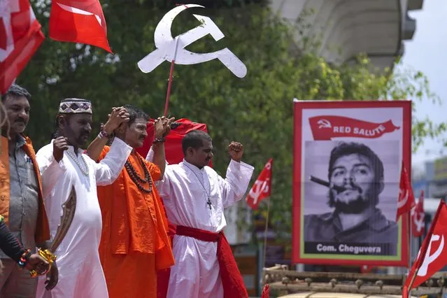 Members of the Centre of India Trade Unions (CITU) dressed as Muslim, Hindu and Christian priests stand next to a picture of Cuban revolutionary leader Che Guevara during a rally to mark May Day in Hyderabad, India, Monday, May 1, 2023. (Photo by Mahesh Kumar A./AP Photo)