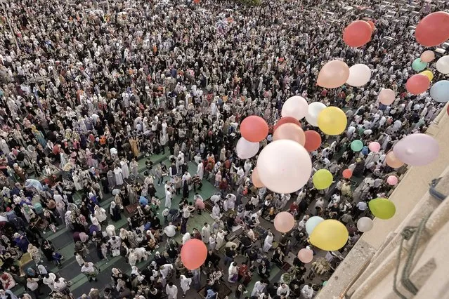 Balloons are distributed for free after Eid al-Fitr prayers, marking the end of the Muslim holy fasting month of Ramadan outside al-Seddik mosque in Cairo, Egypt, Friday, April 21, 2023. (Photo by Amr Nabil/AP Photo)