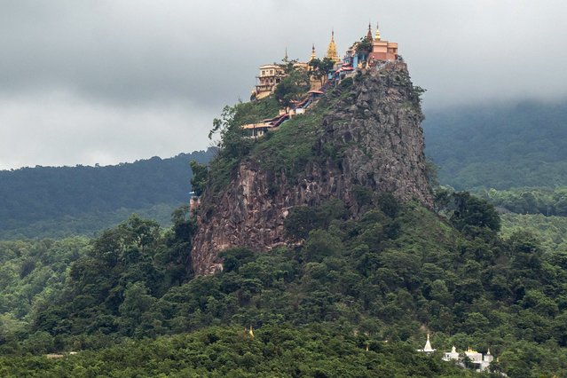 This photo taken on July 7, 2024 shows a general view of the Taung Kalat Buddhist complex on Mount Popa in central Myanmar's Mandalay Region. A shrine perched on an extinct volcano in Myanmar once thronged with the bustle of pilgrims praying to flower-eating spirit Popa Maedaw, but civil war has cut the complex off from the faithful. Now, the prayers have fallen silent at the Taung Kalat shrine, the plains around it a battle zone and the faithful mostly blocked from access by fighting and checkpoints manned by all sides in the conflict. (Photo by Sai Aung Main/AFP Photo)