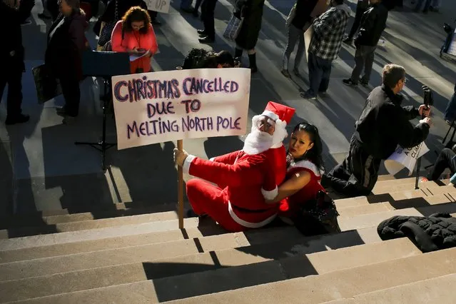 Protesters dressed as Santa Claus take part in a protest about climate change at New York City Hall steps in lower Manhattan, New York, November 29, 2015, a day before the start of the Paris Climate Change Conference (COP21). (Photo by Eduardo Munoz/Reuters)