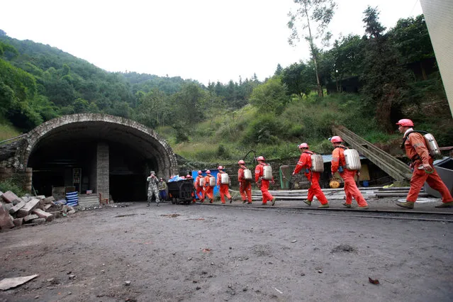 Rescuers carry materials and walk to a cave at the site of a coal mine explosion in Chongqing, China, November 1, 2016. (Photo by Zhou Shijie/Reuters)