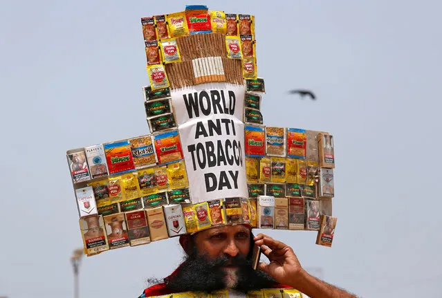 Rajendra Kumar Tiwari, a social activist, wearing a headgear made from empty cigarettes packets speaks on his mobile phone as he conducts an anti-tobacco awareness campaign to mark “World No Tobacco Day” in Mumbai, India, May 31, 2018. (Photo by Francis Mascarenhas/Reuters)