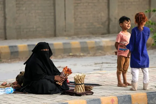 A mother works on a roadside next to her children during Mother's day in Peshawar, Pakistan, 14 May 2023. Mother's Day is celebrated on the second Sunday of May in a large number of countries to honor mothers and for appreciation of motherhood. (Photo by Bilawal Arbab/EPA/EFE)