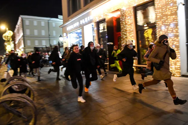 People run during a protest against a court ruling ordered Russian opposition leader Alexei Navalny jailed for nearly three years, in downtown Moscow early on February 3, 2021. (Photo by Natalia Kolesnikova/AFP Photo)