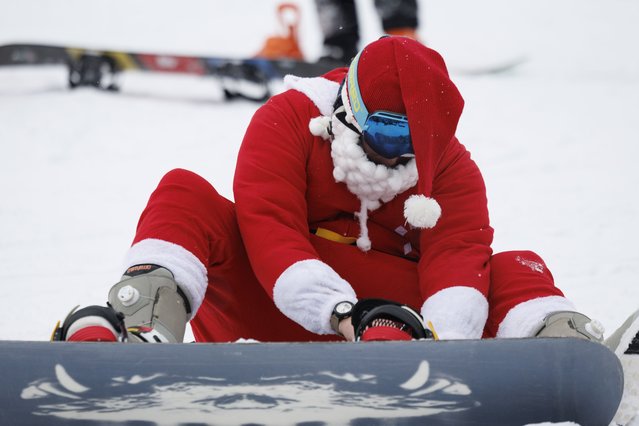 Skiers and snowboarders dressed as Santa Claus prepare to take part in the Sunday Santa ski run at the Sunday River Resort in Newry, Maine, USA, 08 December 2024. More than 300 skiers dressed in Santa-themed costumes skied down the mountain to raise money for the “River Fund”, scholarships for students in western Maine. (Photo by CJ Gunther/EPA/EFE)