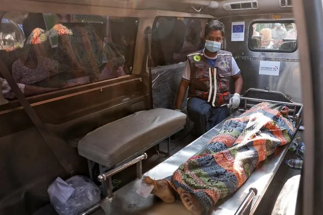 The body of a woman who was shot dead yesterday while police were trying to disperse an anti-coup demonstration is seen inside an ambulance before her funeral in Mandalay, Myanmar, March 1, 2021. (Photo by Reuters/Stringer)