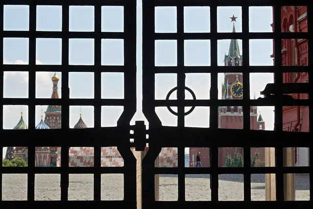 A person (C-R, rear), seen through a gate, walks in the blocked Red Square in Moscow, Russia, 25 June 2023. Moscow's Red Square remained closed on the day after security in the city was tightened. On 24 June, counter-terrorism measures were enforced in Moscow and other Russian regions after private military company (PMC) Wagner Group's chief claimed that his troops had occupied the building of the headquarters of the Southern Military District in Rostov-on-Don, demanding a meeting with Russia's defense chiefs. Belarusian President Lukashenko, a close ally of Putin, negotiated a deal with Wagner chief Prigozhin to stop the movement of the group's fighters across Russia, the press service of the President of Belarus reported. The negotiations were said to have lasted for the entire day. Prigozhin announced that Wagner fighters were turning their columns around and going back in the other direction, returning to their field camps. (Photo by Maxim Shipenkov/EPA/EFE)