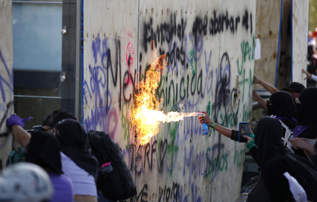 Women attack Mexico's Revolution Monument during a march to commemorate International Women's Day and to protest against gender violence, in Mexico City, Monday, March 8, 2021. (Photo by Rebecca Blackwell/AP Photo)