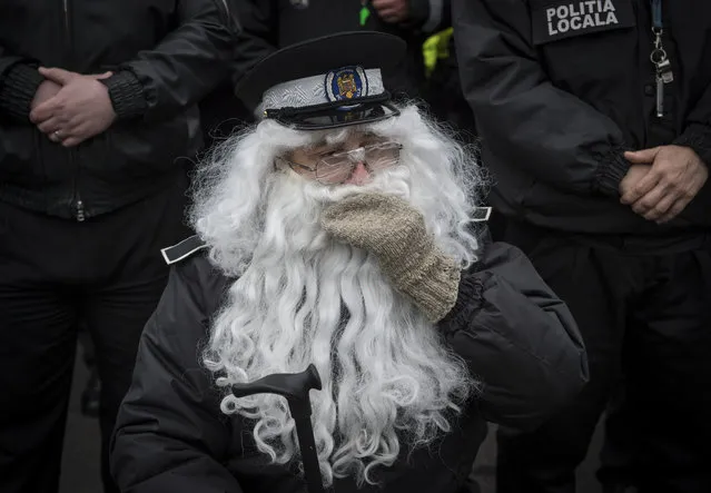 Romanian local police officers wear fake beards to impersonate an elderly employee during a protest in Bucharest on November 22, 2016. Around 1000 local police officers take part in a protest next to the Romanian Government headquarters to ask for the lower of the retirement age as the actual age is 65 years. (Photo by Daniel Mihailescu/AFP Photo)