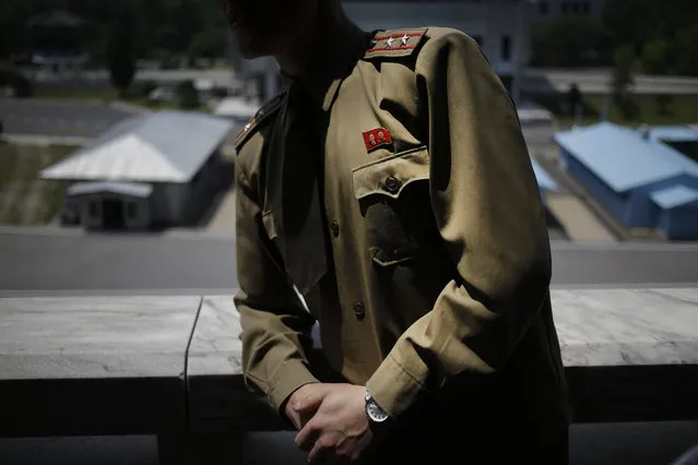 North Korean Army Lt. Colonel Hwang Myong Jin wears a pin of late North Korean leaders Kim Il Sung and his son Kim Jong Il while explaining the history of the truce village at the Demilitarized Zone (DMZ) which separates the two Koreas in Pammunjom, North Korea, Wednesday, June 20, 2018. Hwang who has been a guide on the northern side of the Demilitarized Zone that divides the two Koreas for five years says that since the summits between North Korean leader Kim Jong Un and the presidents of South Korea and the United States, things have quieted down noticeably in perhaps the most iconic symbol of the one last place on Earth where the Cold War still burns hot. (Photo by Dita Alangkara/AP Photo)